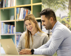 Twee medewerkers van Woonwaarts die werken achter een bureau