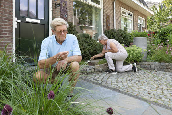 Ouder echtpaar in de voortuin